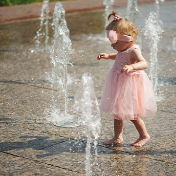 young girl playing in the water on a splash pad